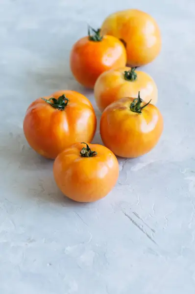 Tomates maduros frescos amarelos em um fundo de pedra branca. Despesas gerais — Fotografia de Stock