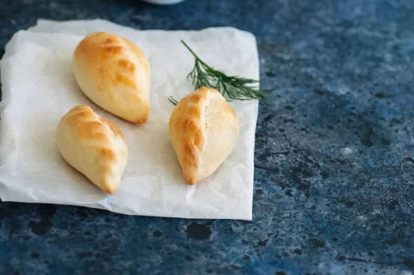 Pequeños puré de patatas empanadas (pasteles de mano) en un tazón blanco en un panecillo — Foto de Stock