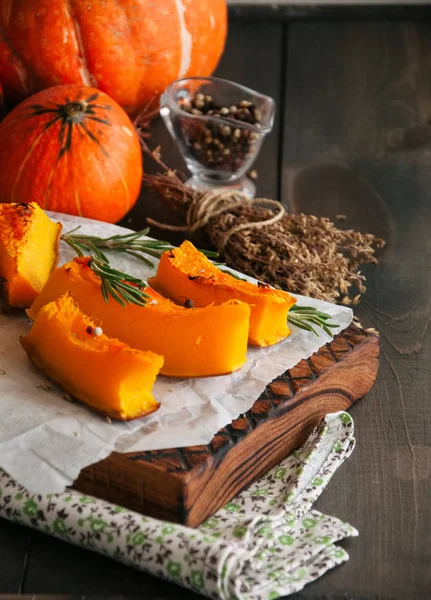 Geröstete Kürbisscheiben mit Rosmarin und trockenem Thymian auf einem Backblech — Stockfoto