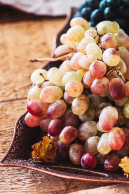 Vintage bir tepsi üzerinde ahşap bir demet taze olgun üzüm servis