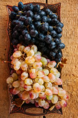 Vintage bir tepsi üzerinde ahşap bir demet taze olgun üzüm servis