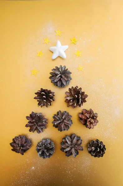 Árvore de Natal de cones de abeto sobre fundo dourado. Tonificado — Fotografia de Stock