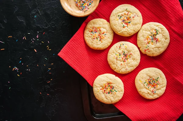 Печенье с печеньем и конфетти на красной салфетке на черном кастрюле — стоковое фото
