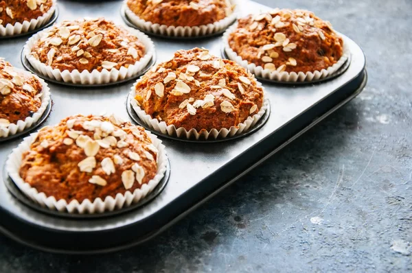 Carrot cake muffins with nuts, raisins and oats on a blue stone — Stock Photo, Image