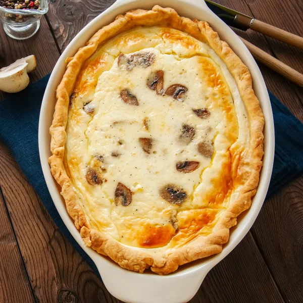 Délicieuse quiche maison aux champignons et fromage dans un plat sur — Photo