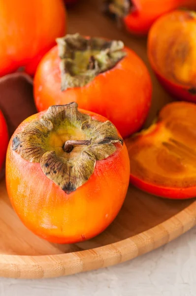 Plate of fresh and ripe persimmons. Close up. — Stock Photo, Image