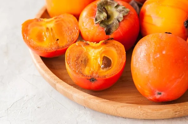 Plate of fresh and ripe persimmons. Close up. — Stock Photo, Image