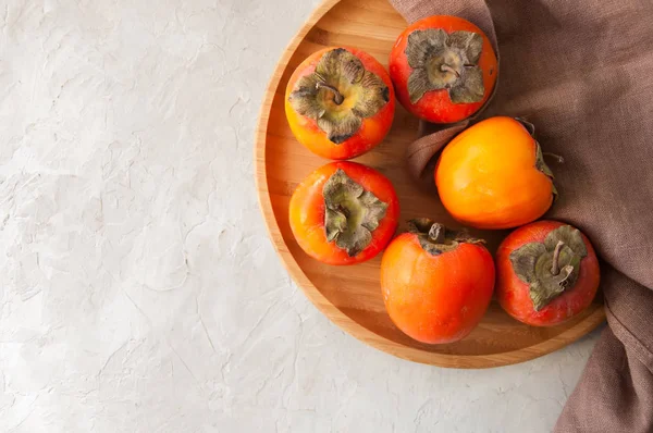 Plate of fresh and ripe persimmons. Top view and copy space. — Stock Photo, Image