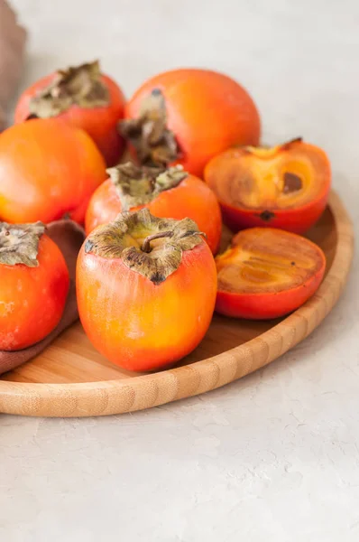 Plate of fresh and ripe persimmons. Close up. — Stock Photo, Image