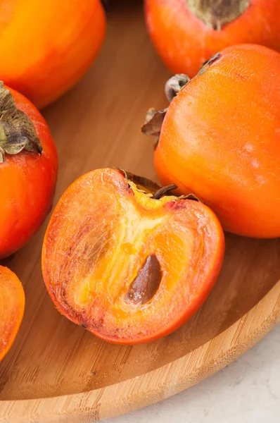 Plate of fresh and ripe persimmons. Close up. — Stock Photo, Image