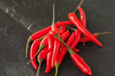 Taze olgun kırmızı sıcak biber siyah bir zemin üzerine