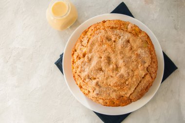 Vanilyalı krema soslu beyaz tabakta İrlandalı elmalı turta. Fes