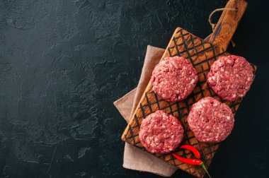 Ham toprak et sığır eti burgers bir ahşap tahta. 