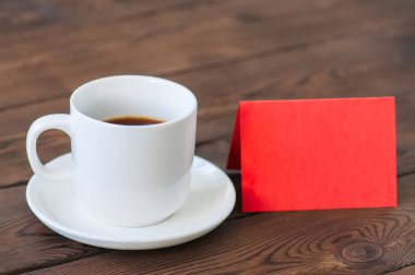 Bir fincan kahve ve bir ahşap zemin üzerinde kart. Sevgililer