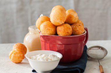 Küçük süzme peynir çörek (castgnole) üzerinde kırmızı bir kase hizmet