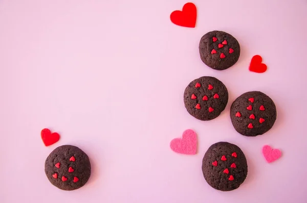 Chocolate cookies with hearts sugar on a pink background. Saint