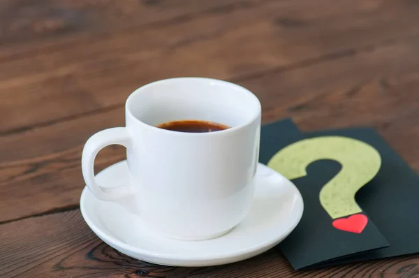 Uma xícara de café preto e cartão em um pano de fundo de madeira. São Valentim — Fotografia de Stock