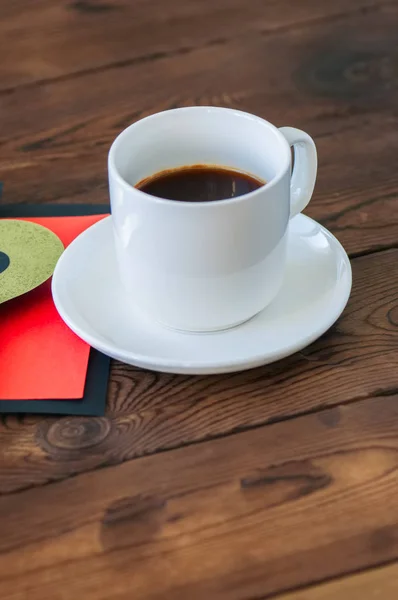 Uma xícara de café preto e cartão em um pano de fundo de madeira. São Valentim — Fotografia de Stock