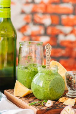 Fesleğen ceviz pesto hammaddelerini ahşap bir boa üzerinde bir kavanoza