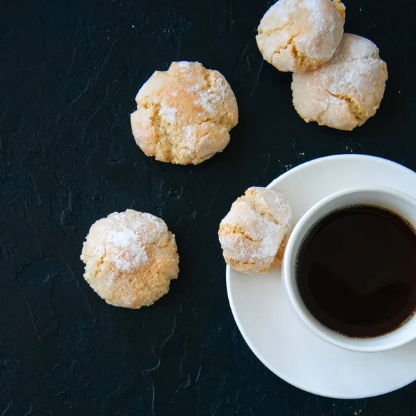 Kopje sterke koffie en amaretti koekjes op een zwarte achtergrond — Stockfoto