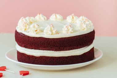 Kırmızı kadife kek krem peynir beyaz bir plaka üzerinde buzlanma ile