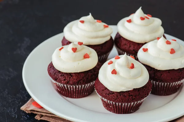 Magdalenas de terciopelo rojo con glaseado de queso crema en un plato blanco —  Fotos de Stock