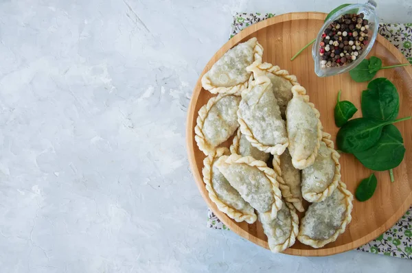 Gebratene pikante Pasteten - Handpastete mit Spinat auf weißem Backblech — Stockfoto