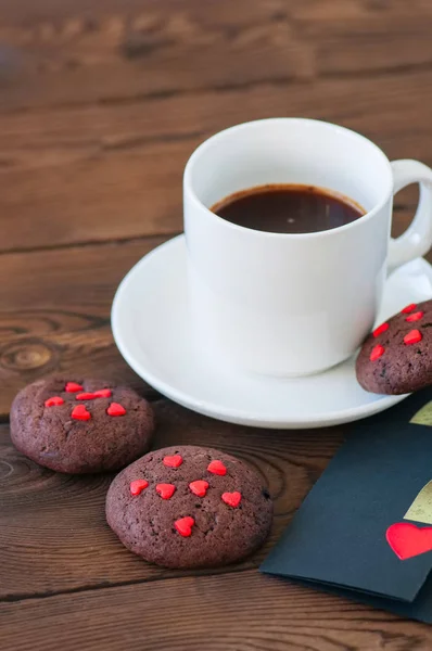 Uma xícara de café preto e biscoitos de chocolate em um pano de fundo de madeira — Fotografia de Stock