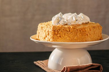 Tatlım pasta üstüne beze dekorasyonu ile hizmet üzerinde beyaz bir pla