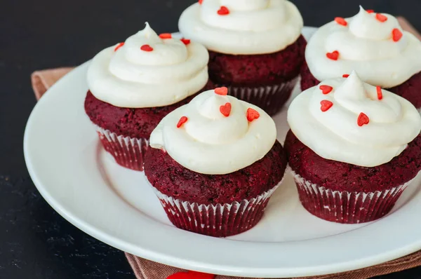 Magdalenas de terciopelo rojo con glaseado de queso crema en un plato blanco —  Fotos de Stock