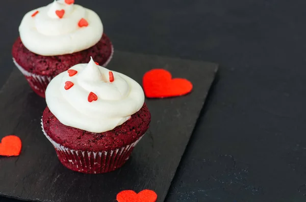 Magdalenas de terciopelo rojo con glaseado de queso crema en un plato blanco —  Fotos de Stock