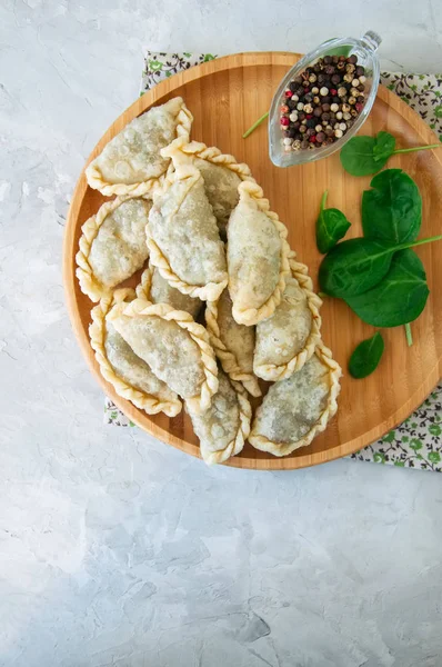 Gebratene pikante Pasteten - Handpastete mit Spinat auf weißem Backblech — Stockfoto