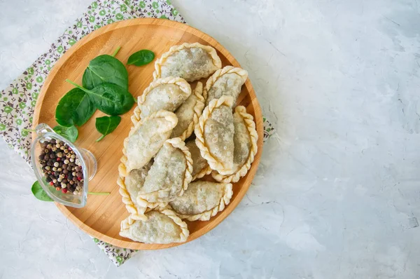 Gebratene pikante Pasteten - Handpastete mit Spinat auf weißem Backblech — Stockfoto