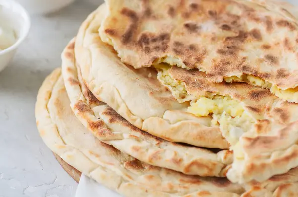 Purê de batata e queijo de ovelha recheio flatbread em um ston branco — Fotografia de Stock