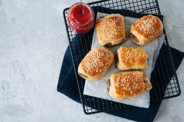 Sığır eti ve caramelised soğan sosis rolls ile ahşap bir plaka üzerinde 
