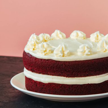 Kırmızı kadife kek krem peynir beyaz bir plaka üzerinde buzlanma ile