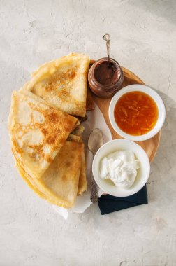 Lezzetli krepler (blinis) ahşap bir plaka üzerinde çeşitli soslar