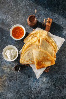 Lezzetli krepler (blinis) ahşap bir tahta üzerinde çeşitli soslar