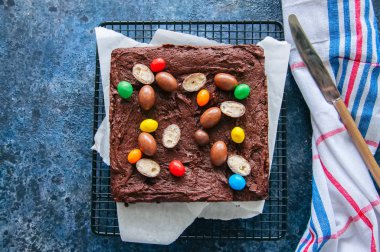 Dark chocolate brownie square on a wire rack decorated with crea clipart