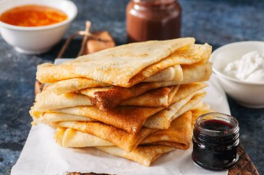 Lezzetli krepler (blinis) ahşap bir tahta üzerinde çeşitli soslar