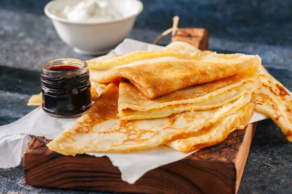 Délicieuses crêpes (blinis) avec sauces assorties sur une planche en bois — Photo