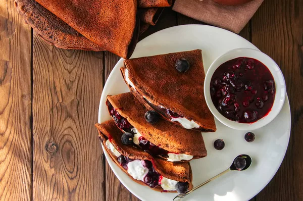 Chocolate crepes (blinis) with sour cream and black currant sauc — Stock Photo, Image