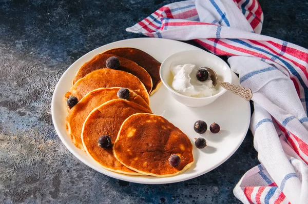 Cottage cheese pancakes with sour cream and berries on a white p — Stock Photo, Image