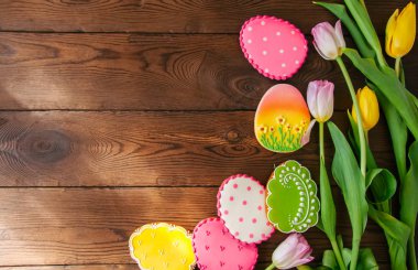 Ahşap ba üzerinde sepetteki renkli Paskalya bunny ve yumurta kurabiye