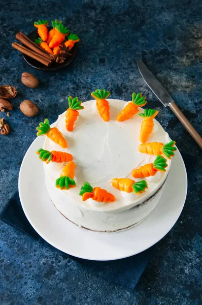 Carrot cake with cream cheese frosting decorated with carrot mar