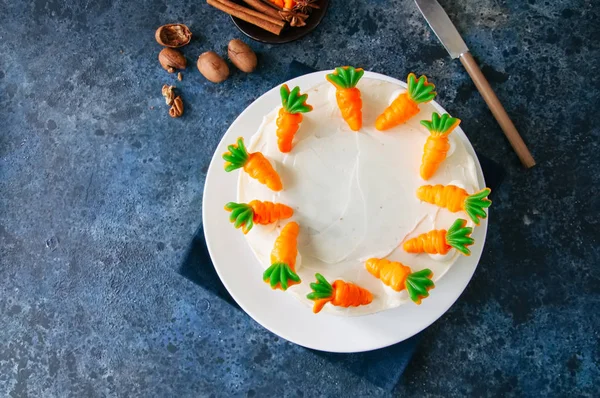 Carrot cake with cream cheese frosting decorated with carrot mar