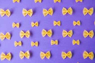 Farfalle makarna mor bir arka plan üzerinde yay. Üstten Görünüm.