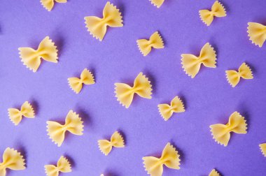 Farfalle makarna mor bir arka plan üzerinde yay. Üstten Görünüm.