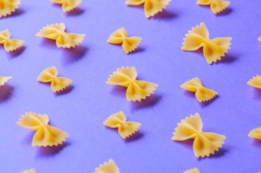 Farfalle makarna mor bir arka plan üzerinde yay. Üstten Görünüm.