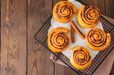 Klasik rulo tarçın - Cinnabon bir tel raf kazandı. Ahşap backg